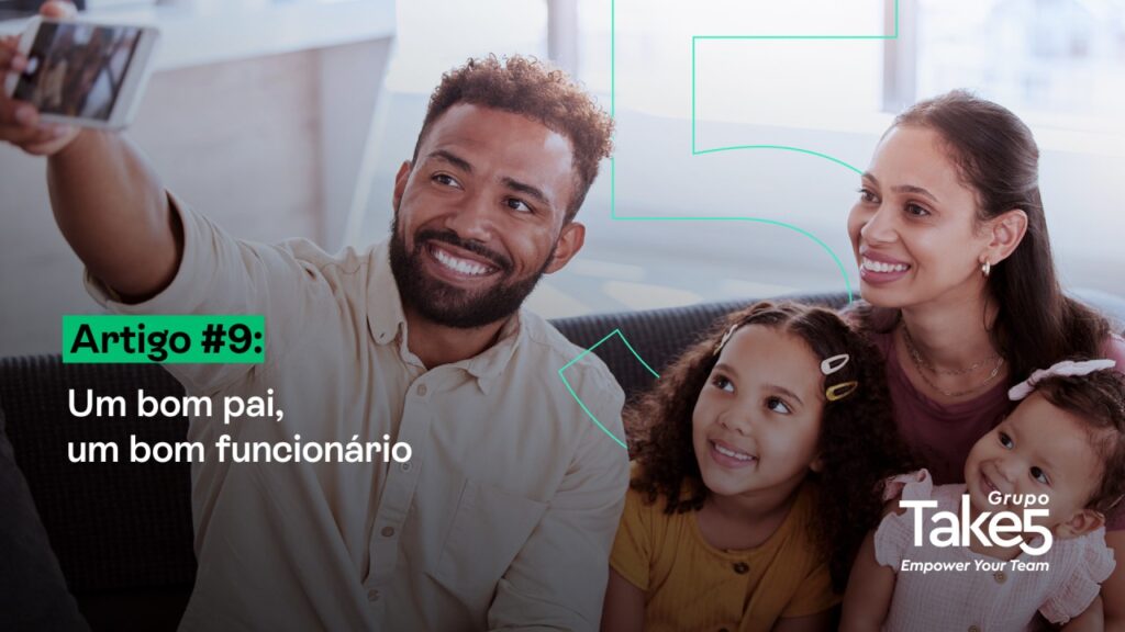 Homem tirando uma selfie com a família no sofá, ao lado da parceira e das duas filhas, representando paternidade ativa, equilíbrio entre vida pessoal e profissional, bem-estar familiar e engajamento no trabalho.