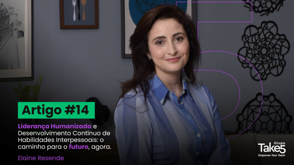 Mulher profissional sorrindo, vestindo camisa azul clara, em ambiente corporativo com quadros decorativos ao fundo, representando liderança humanizada, desenvolvimento de habilidades interpessoais e educação corporativa.