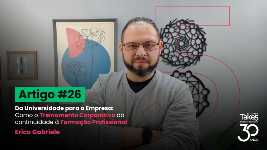 Homem de braços cruzados em ambiente corporativo, usando óculos e blusa cinza, posicionado em frente a quadros decorativos na parede. À esquerda, texto em destaque: “Artigo #26 – Da Universidade para a Empresa: Como o Treinamento Corporativo dá continuidade à Formação Profissional – Érico Gabriele”. À direita, identidade visual do Grupo Take5 com selo de 30 anos.