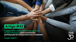 Mãos de diferentes profissionais unidas em gesto de colaboração, representando engajamento corporativo, trabalho em equipe e programas de aprendizagem focados em resultados, com identidade do Grupo Take 5.