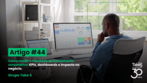 Profissional analisando dashboards e KPIs em computador para medir resultados de treinamento corporativo.