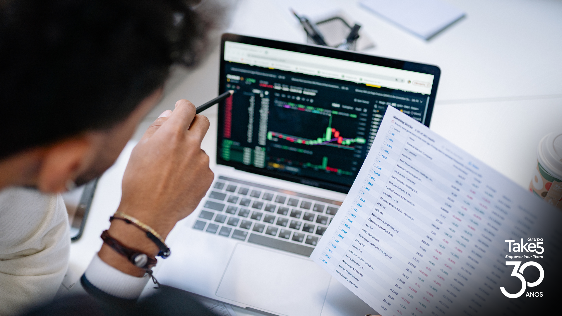 Profissional analisando dados e relatórios em notebook para tomada de decisão baseada em indicadores.