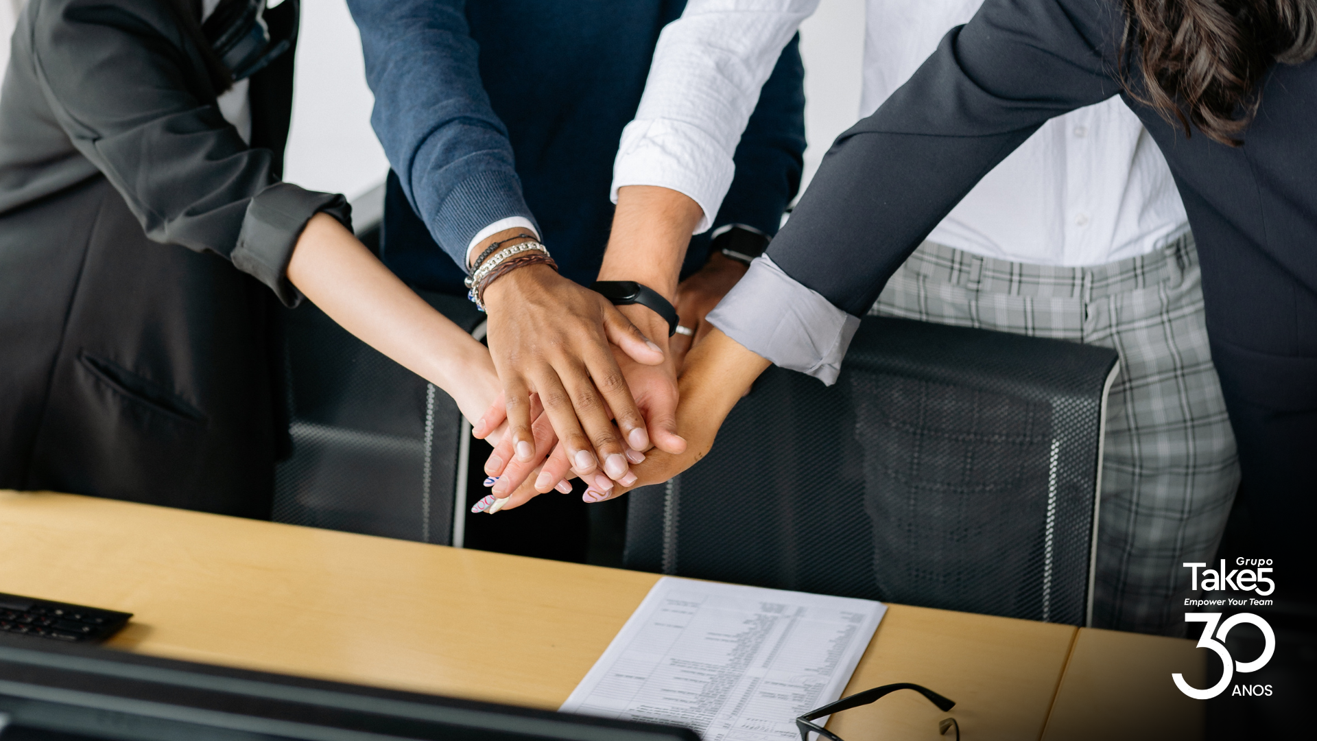 Mãos de colaboradores unidas simbolizando engajamento, comprometimento e aplicação prática no trabalho.